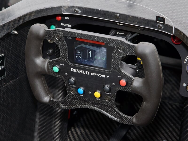 Volant de course Renault Sport en fibre de carbone avec boutons colorés dans une monoplace de Formule Renault.