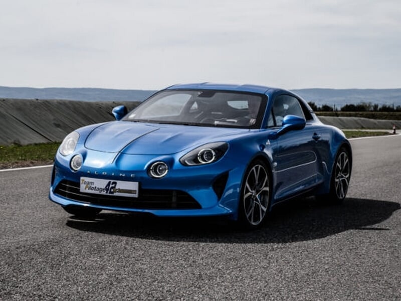 Alpine A110 sur circuit asphalte, coaching pilotage avec pilote casqué.