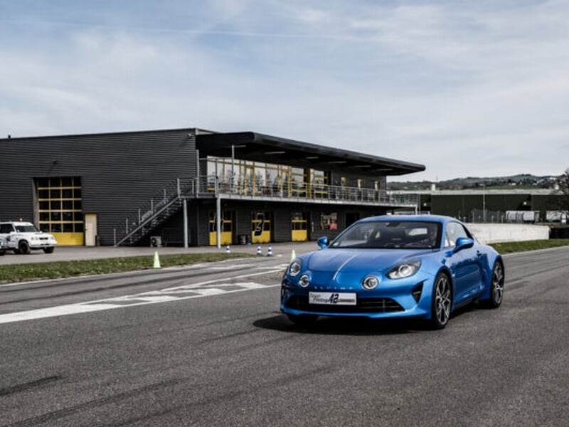 Alpine A110 sur circuit asphalte, coaching pilotage avec pilote en pleine concentration.