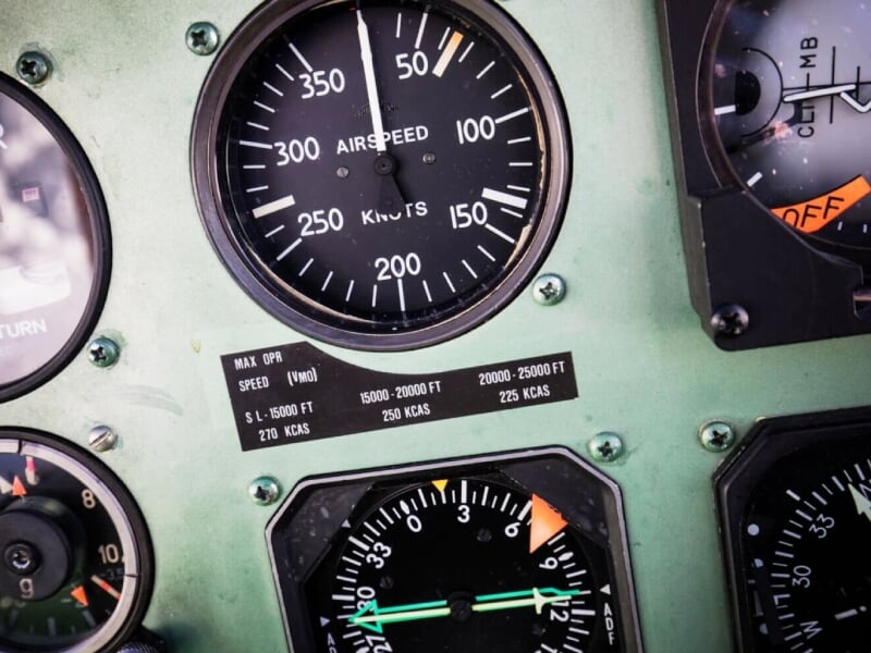 Tableau de bord d'un avion avec plusieurs instruments de vol visibles, indiquant la vitesse et l'altitude.