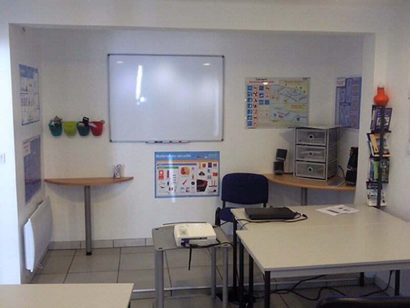 Salle de formation avec tableau blanc, chaises, tables et matériel pédagogique pour permis bateau à Carantec.