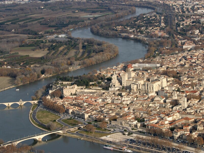 Vue aérienne d'une ville traversée par une rivière avec plusieurs ponts et un centre historique dense et ancien.