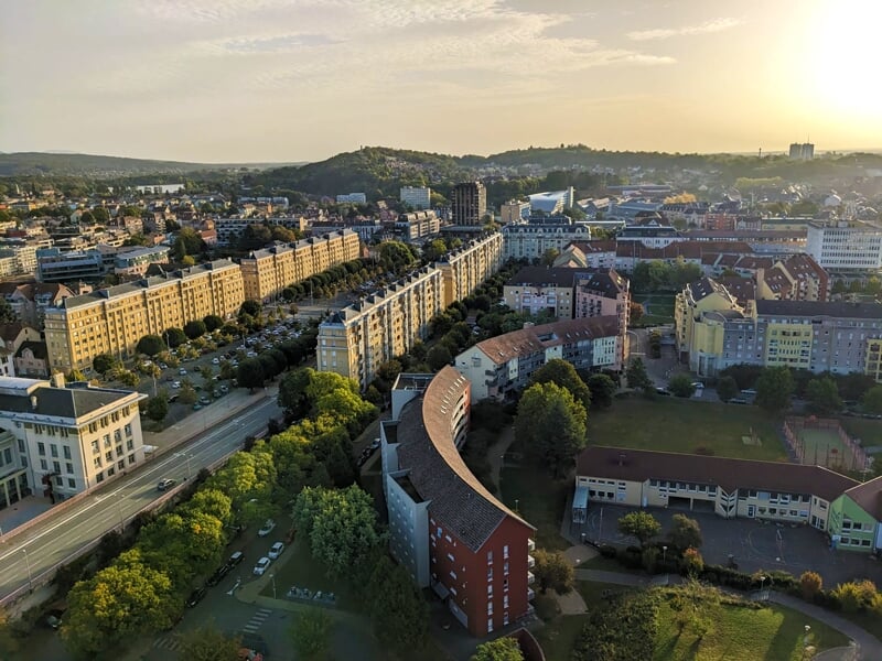 Lumière dorée du soleil couchant sur une ville avec des bâtiments modernes et une rue sinueuse