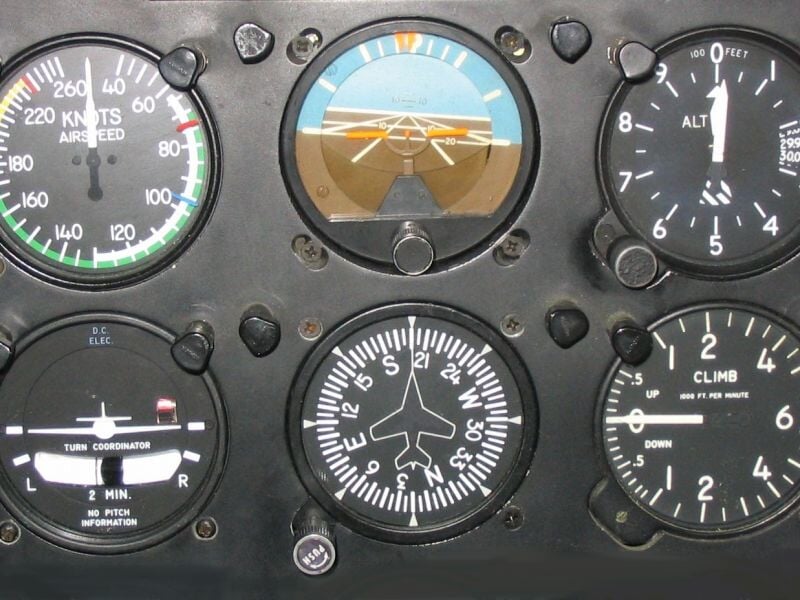 Gros plan sur le tableau de bord d'un simulateur de vol avec plusieurs cadrans et instruments de pilotage.