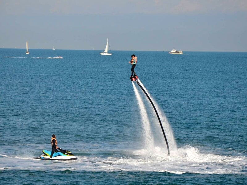 une personne en flyboard et un moniteur en jet-ski dans la mer