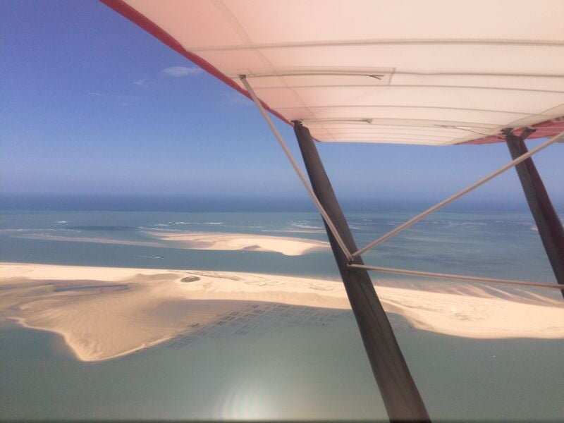 Paysage côtier avec bancs de sable et mer bleue vu depuis un avion ultraléger motorisé en vol.