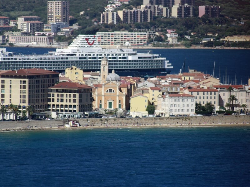 Vue sur une ville côtière avec un grand bateau de croisière amarré près des bâtiments historiques
