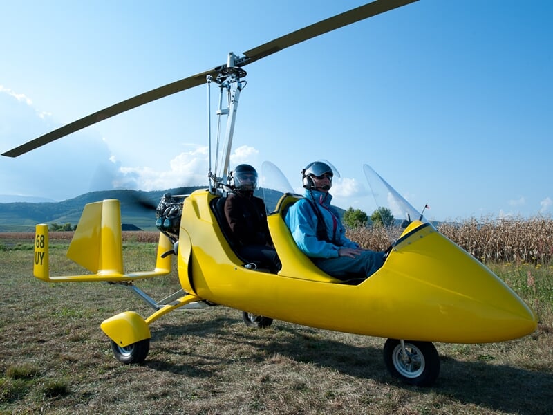 ULM autogire posé au sol avec un pilote et un passager