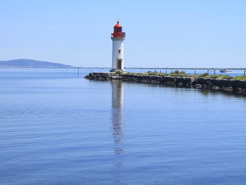 Phare d'onglous à Marseillan avec une une mer d'huile en premier plan