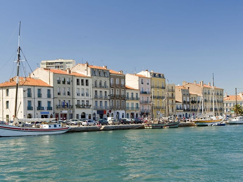 Le canal du port de Sète avec les maisons colorées typiques de la région et les eaux bleutées du chenal