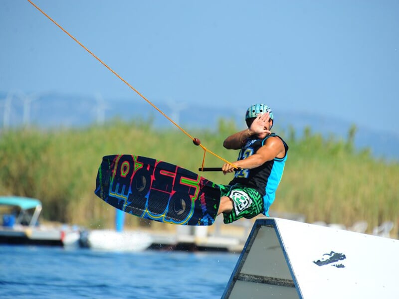 Homme en wakeboard en train d'effectuer une figure dans les airs