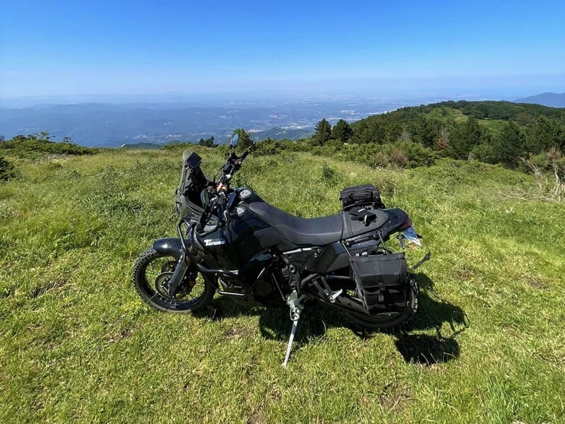 une moto de trail devant un beau panorama sur l'Aude