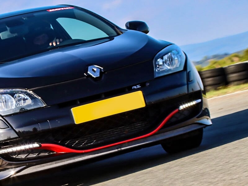 Gros plan sur une Mégane RS noire roulant sur circuit