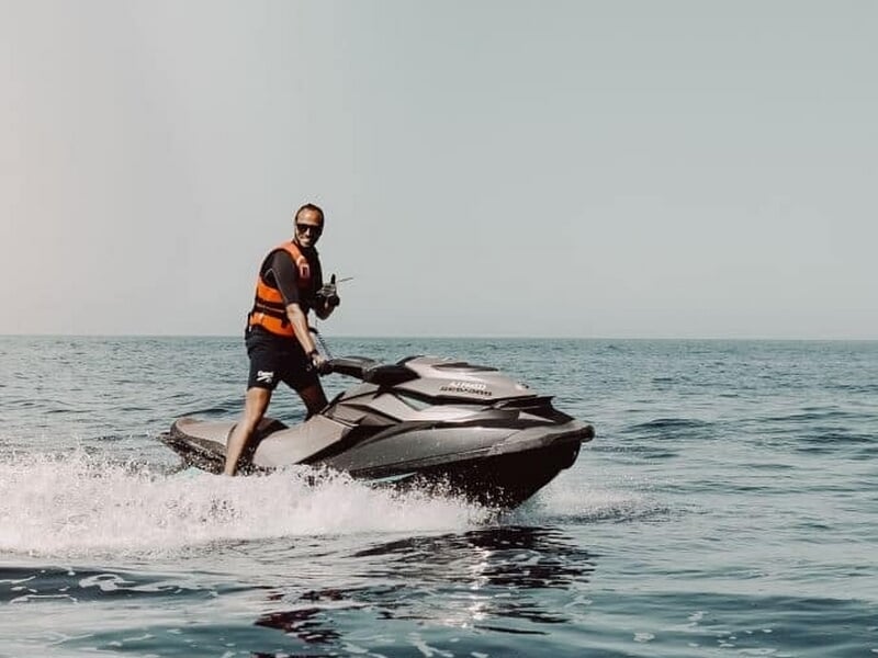 Homme en gilet de sauvetage conduisant un jetski noir lors d'une randonnée jet ski à Porticcio.