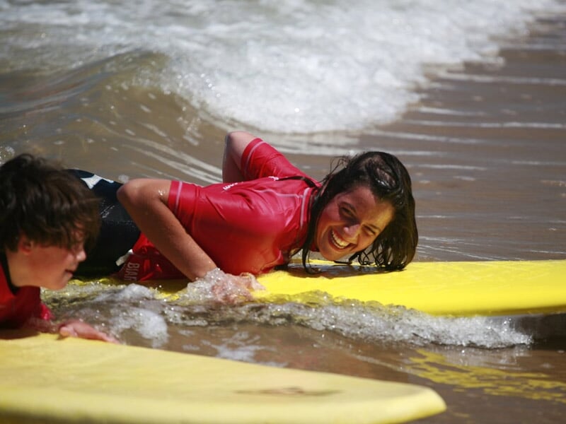 deux personnes s'amusent en surfant leurs premières vagues