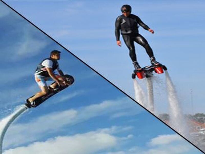 Deux personnes pratiquent le flyboard, volant au-dessus de l'eau avec des jets puissants sous leurs pieds.