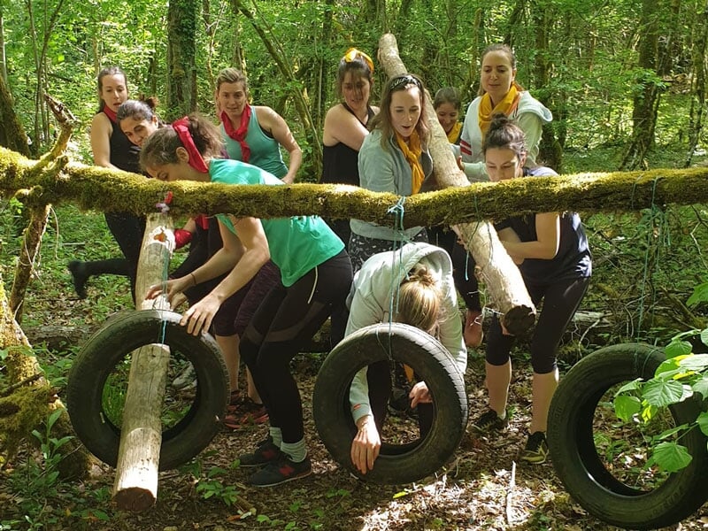 des femmes font un pacours de combattant avec des pneus et des obstacles insolites
