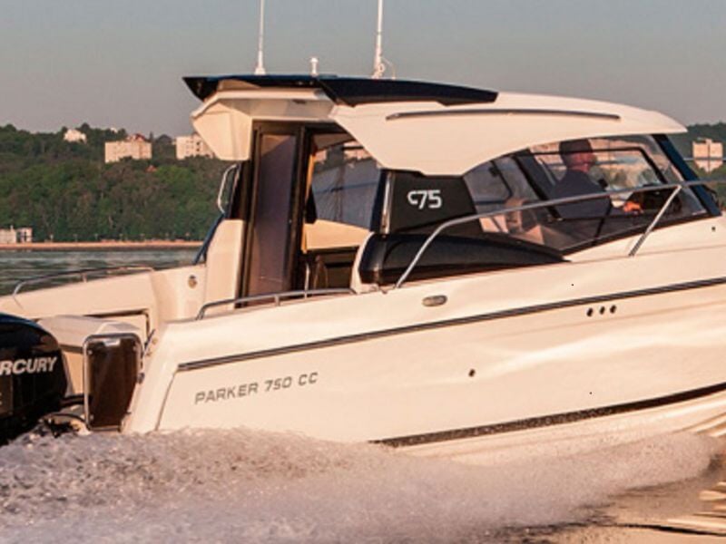 Bateau de plaisance blanc naviguant sur l'eau avec un moteur Mercury et un paysage boisé en arrière-plan.