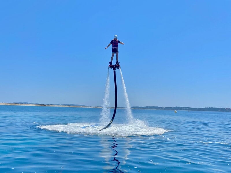Personne en flyboard sur la mer, entourée d'un cercle d'eau formé par la propulsion du jet d'eau.