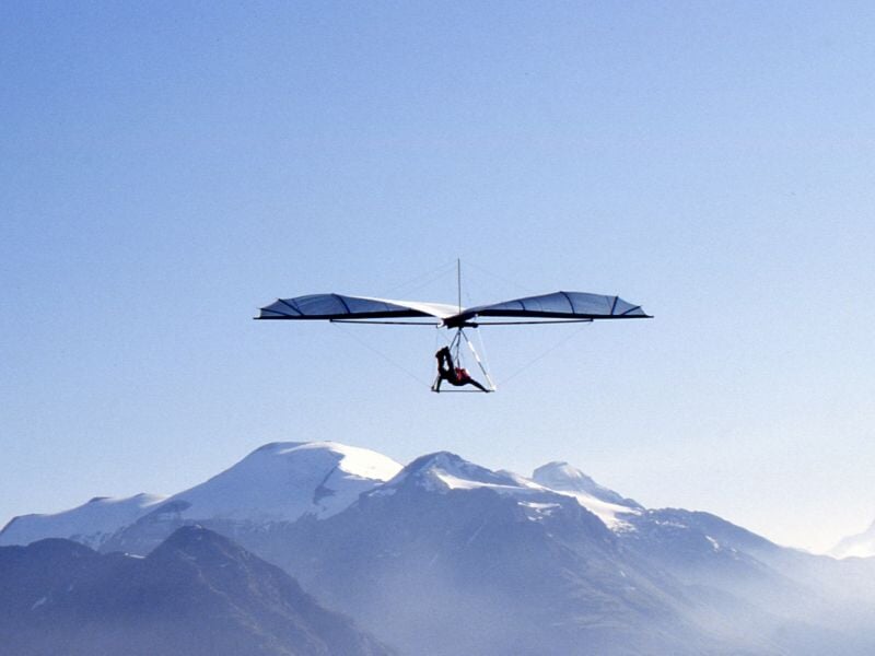 un deltaplane face aux Alpes enneigées