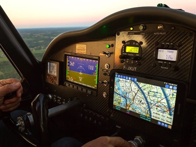 intérieur d'un cockpit d'avion ULM multiaxes en plein vol avec un écran GPS et des instruments de navigation
