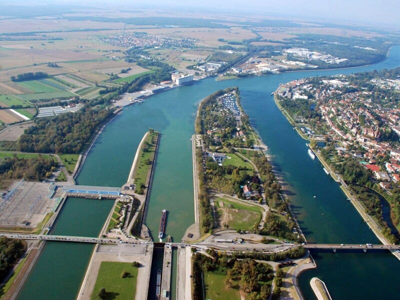 Vue aérienne d'un port fluvial avec des écluses, des bateaux et des infrastructures industrielles.