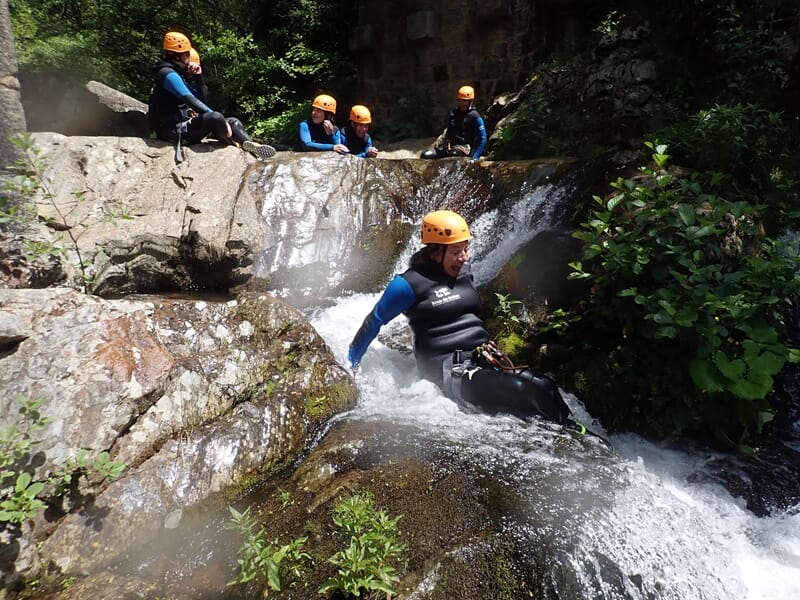 Groupe de personnes glissant sur un toboggan lors d'une sortie canyoning