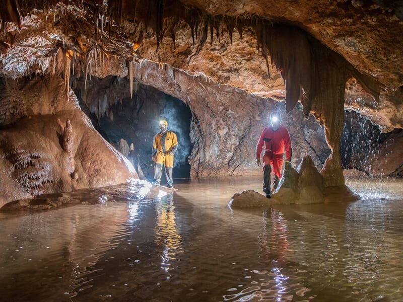 Deux personnes pratiquant la spéléologie dans une grotte