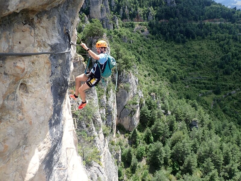 Personne pratiquant l'escalade avec vue sur la forêt