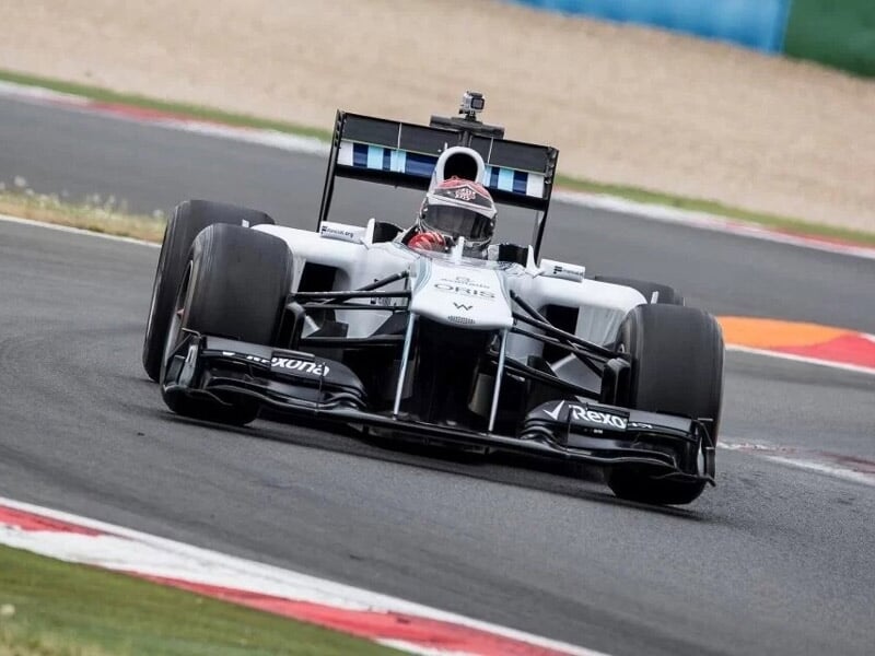 une formule 1 blanche dans un virage de circuit