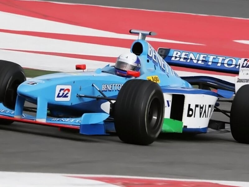 une formule 1 benetton dans un virage de circuit
