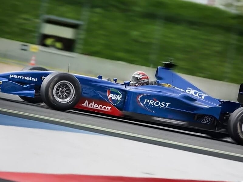 une formule 1 bleue roule à toute vitesse sur un circuit asphalte
