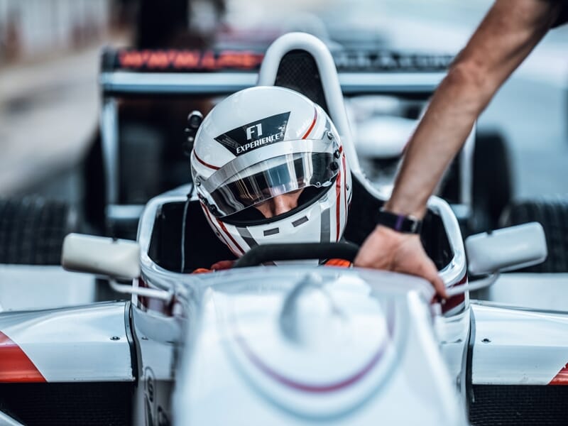 Pilote casqué dans une monoplace de Formule Renault prêt à prendre le départ sur circuit professionnel.