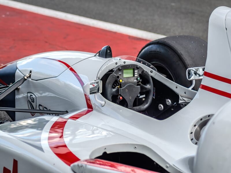 Vue rapprochée du cockpit d'une monoplace de Formule 1 blanche avec des détails rouges sur le circuit de Barcelone.