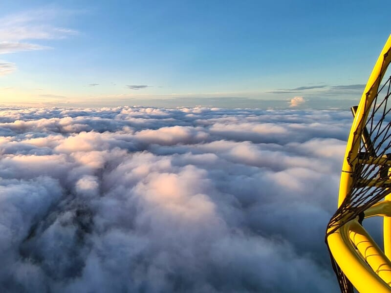 Vue aérienne au-dessus d'un océan de nuages au coucher du soleil, lors d'un séjour insolite dans la Baie de Somme.