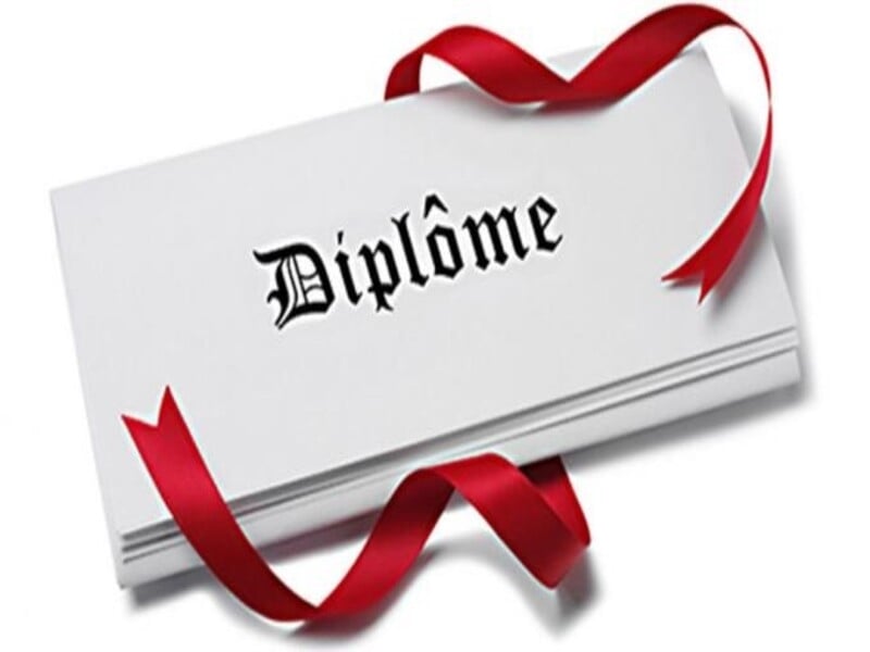 Un diplôme blanc plié avec un ruban rouge attaché, symbolisant la réussite et la remise officielle d'un certificat.