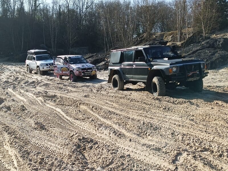 Trois véhicules tout-terrain alignés sur un chemin sablonneux lors d'une randonnée 4x4 près d'Etampes.