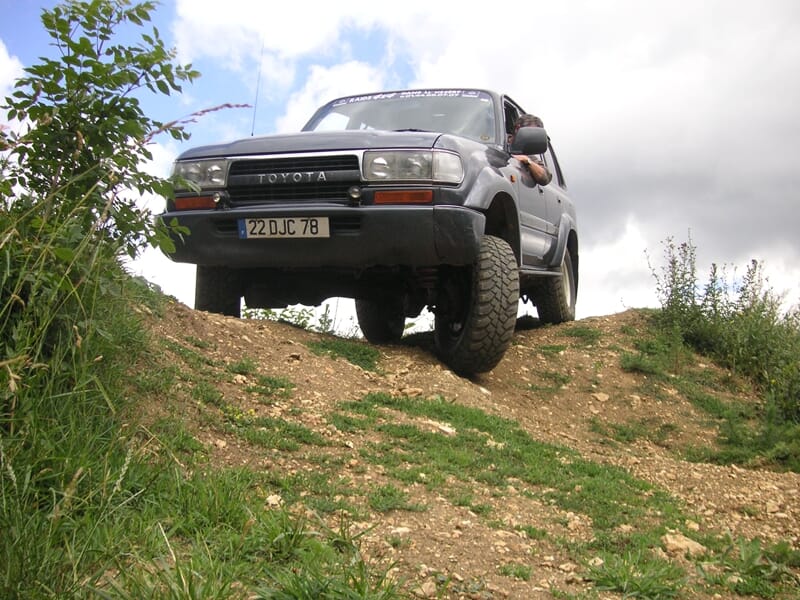 Véhicule Toyota tout-terrain gris sur une pente herbeuse lors d'une randonnée 4x4 près d'Etampes.