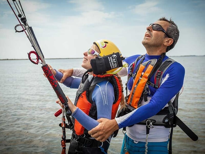 Un homme enseignant le kitesurf à une adolescente