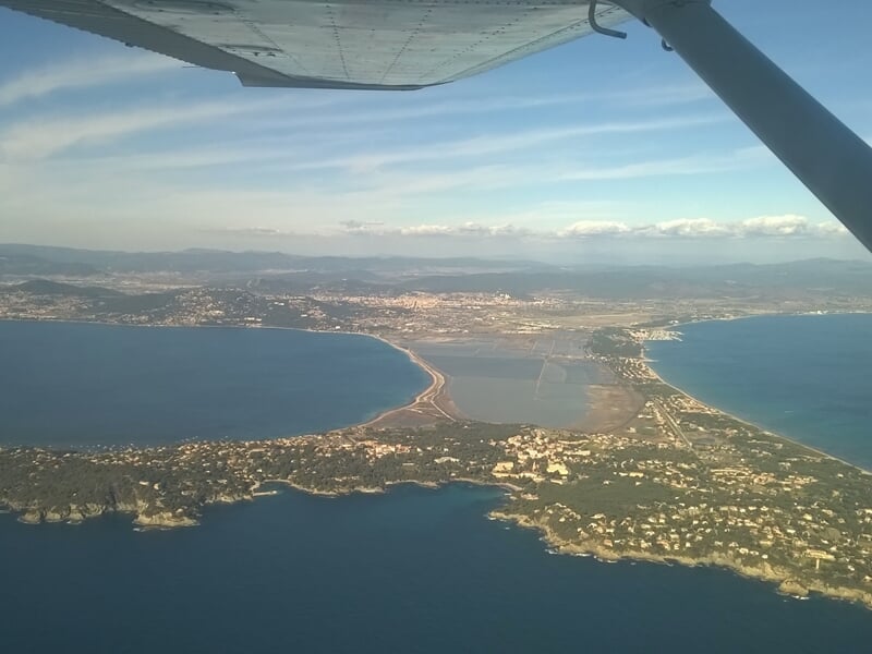 Vue aérienne d'une ville côtière avec une baie et des plages, prise depuis un avion.