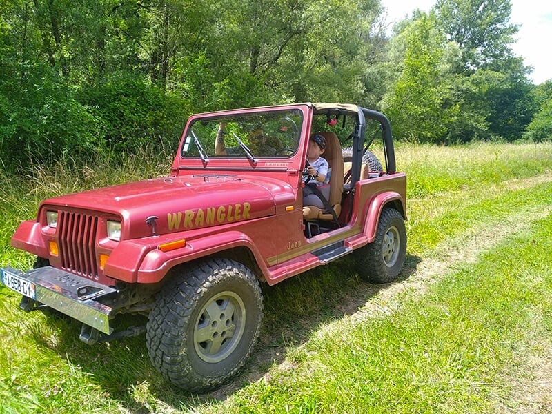 Un enfant conduit une Jeep Wrangler de 120 ch sur une piste privée destinées à l'apprentissage du 4x4