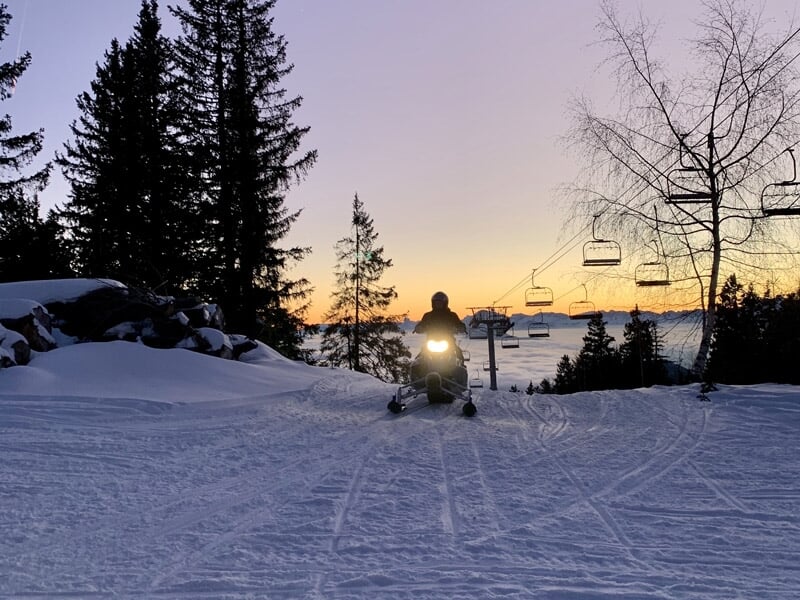 Vue panoramique d'une station de ski avec des pistes enneigées et des remontées mécaniques.