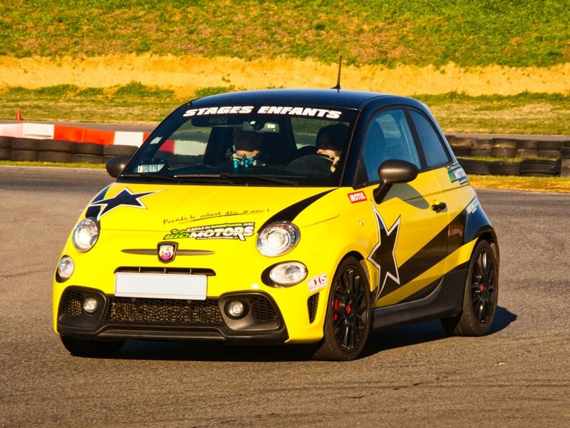 Fiat 500 jaune et noire avec des étoiles noires et le logo 