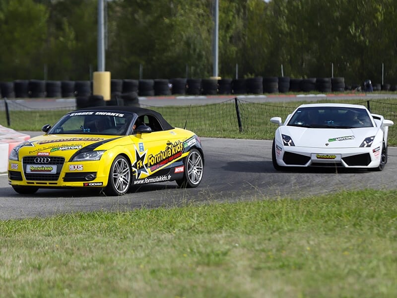 Deux voitures de sport sur un circuit, une Audi TT jaune marquée 