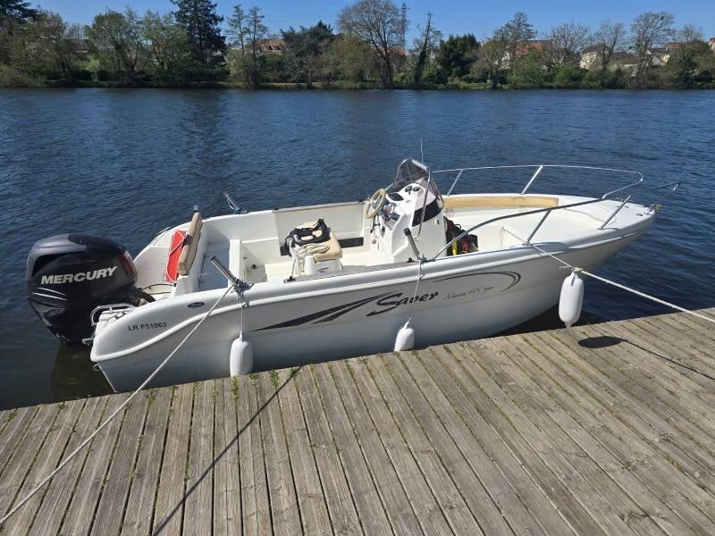 Un bateau école blanc amaré à un ponton.