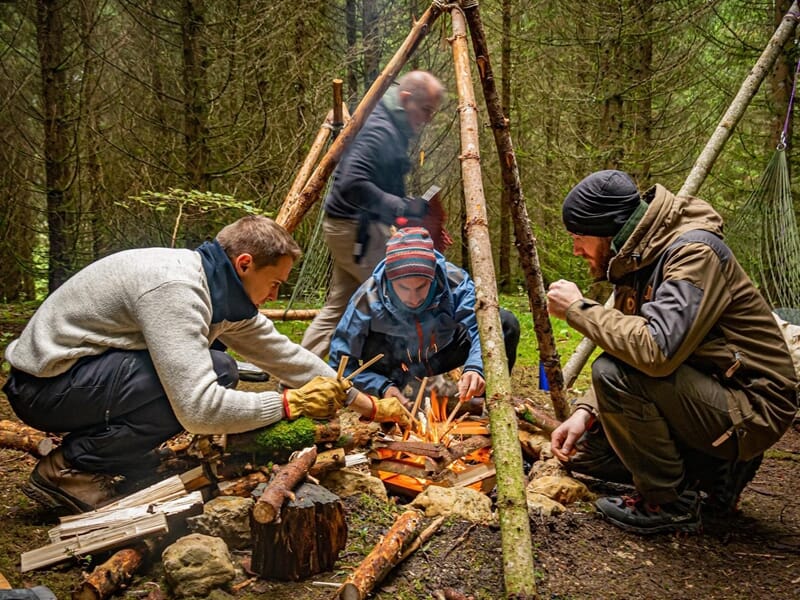 un groupe de personnes nourrissent un feu de camp