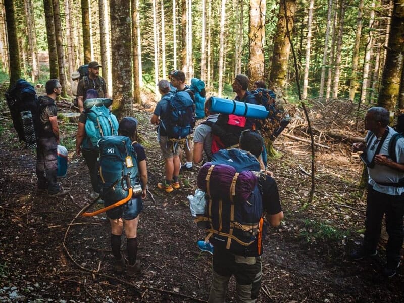 un groupe d'amateurs de survie suivent un briefing en pleine forêt