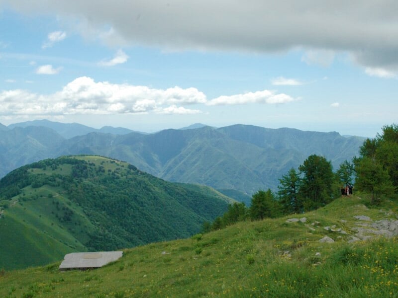 Paysage de montagne avec des collines verdoyantes et un ciel bleu clair avec quelques nuages