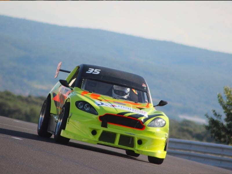 Voiture mitjet jaune fluo et orange sur une piste.