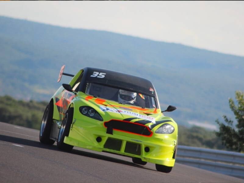 Voiture mitjet jaune fluo et orange sur une piste.